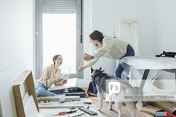 Happy lesbian couple installing new furniture together at home