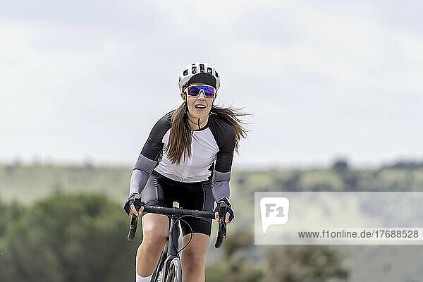 Lächelnder Radfahrer mit Sporthelm und Sonnenbrille beim Fahrradfahren