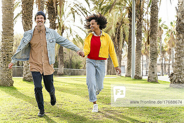Fröhliches Paar läuft zusammen im Park