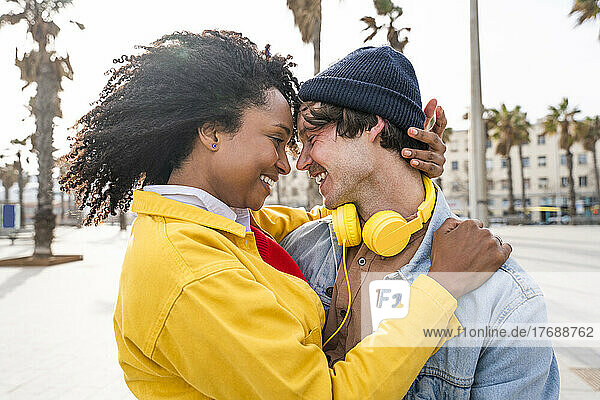 Lächelnde Frau mit Afro-Frisur genießt Freizeit mit Mann