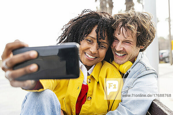 Glückliche Frau und Mann machen Selfie per Smartphone