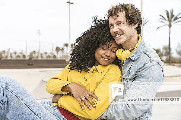 Smiling woman with eyes closed leaning on boyfriend