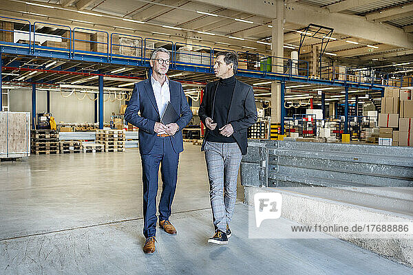 Business people discussing and walking in warehouse