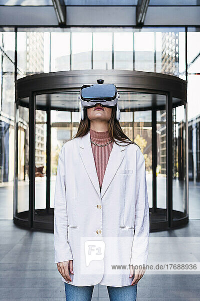 Businesswoman with virtual reality simulator standing at office building