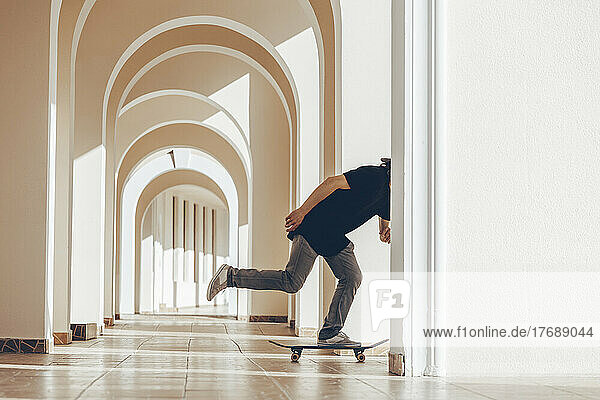 Man with skateboard practicing in arcade
