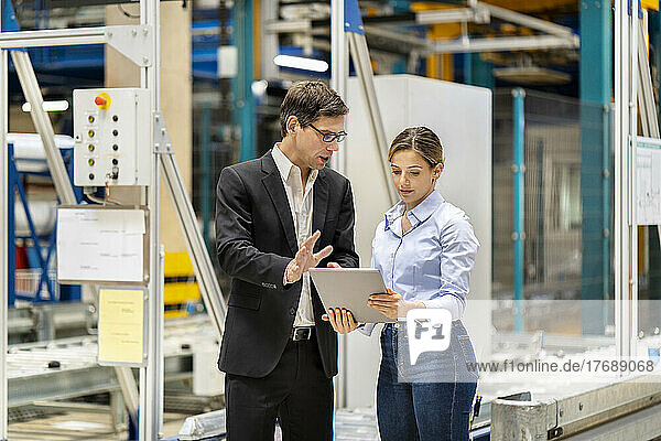 Businessman discussing with colleague over tablet PC at warehouse