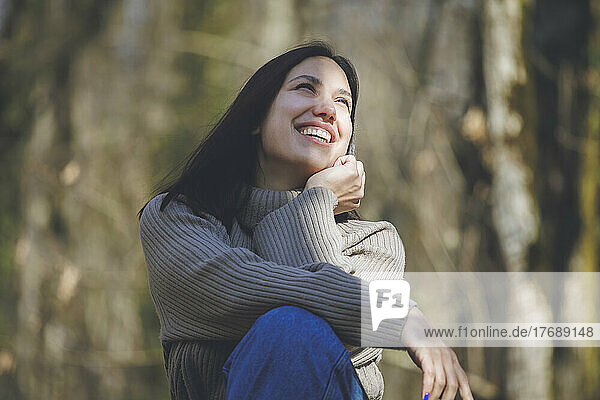 Cheerful young beautiful woman in forest on sunny day