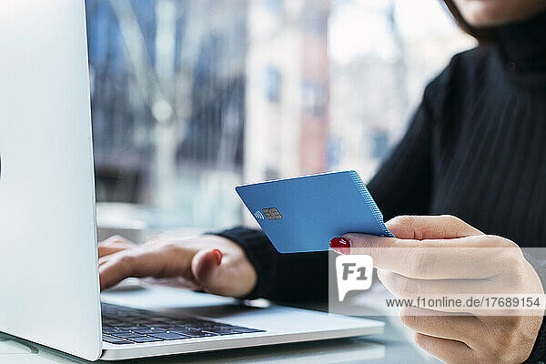 Businesswoman holding credit card using laptop