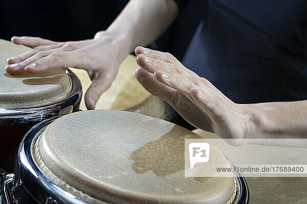 Hands of percussionist playing conga drum