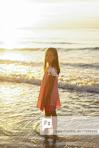 Girl standing at beach on sunny day