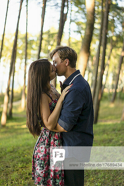 Young couple kissing each other in forest