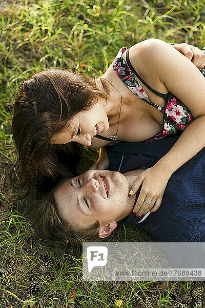 Happy young couple lying on grass