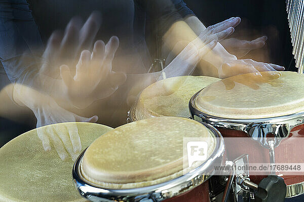 Hands of woman playing bongo