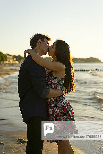 Liebevolles Paar küsst sich am Strand