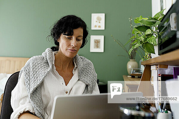 Geschäftsfrau benutzt Laptop und arbeitet zu Hause