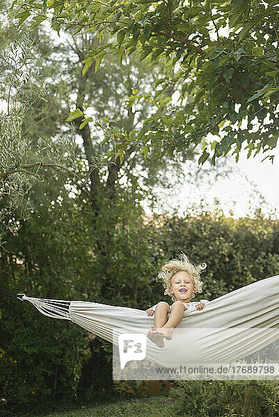 Girl swinging in hammock at garden
