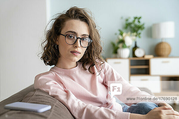Junge Frau mit Brille im Wohnzimmer