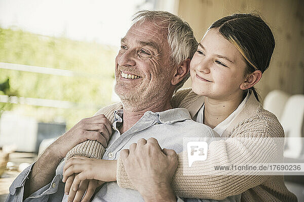 Happy senior man with granddaughter at home