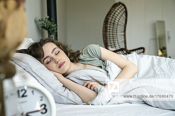 Young woman sleeping in bed at home