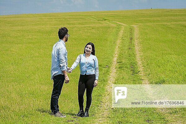Zwei Personen  die sich im Feld an den Händen halten  Schönes Paar  das sich im Feld an den Händen hält  zwei Liebende im Feld  die sich an den Händen halten