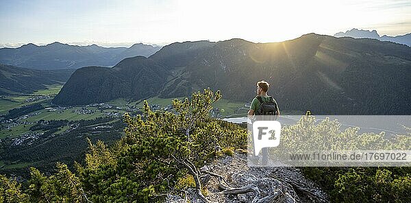 Wanderer steht auf Wanderweg zwischen Latschenkiefern  Blick auf Berglandschaft mit Pillersee  Abstieg vom Heimkehrerkreuz  Nuaracher Höhenweg  Loferer Steinberge  Tirol  Österreich  Europa