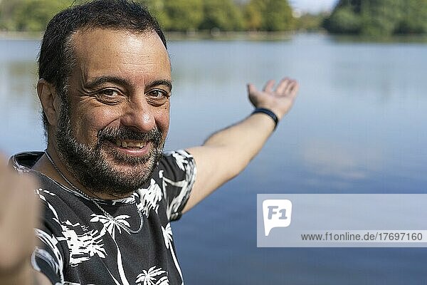 Aktiver gutaussehender reifer kaukasischer Mann  der ein Selfie macht und sich an einem See zeigt. Outdoor-Abenteuer-Konzept
