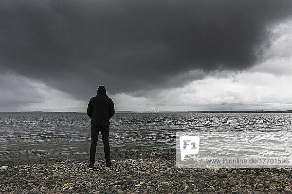 Man standing on shore of Lake Glan  Sweden