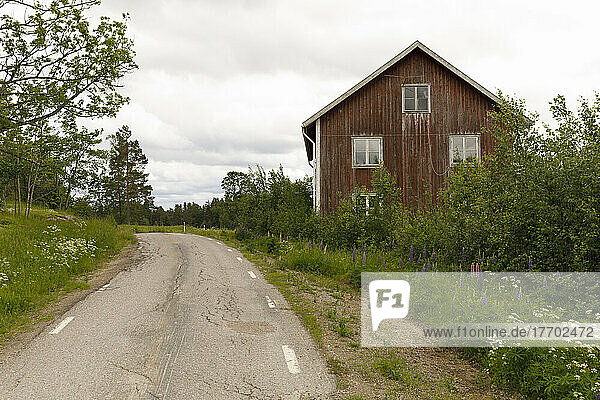 Weathered wooden house by rural road