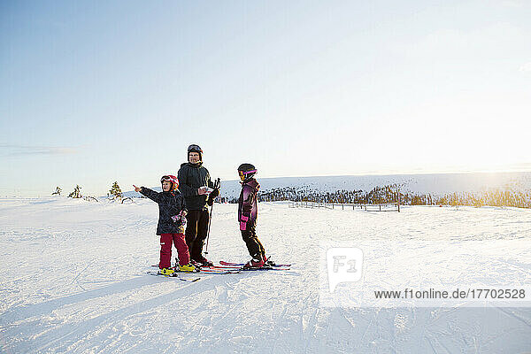 Family standing in snow while skiing
