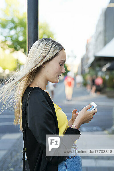 Young woman with smart phone in city