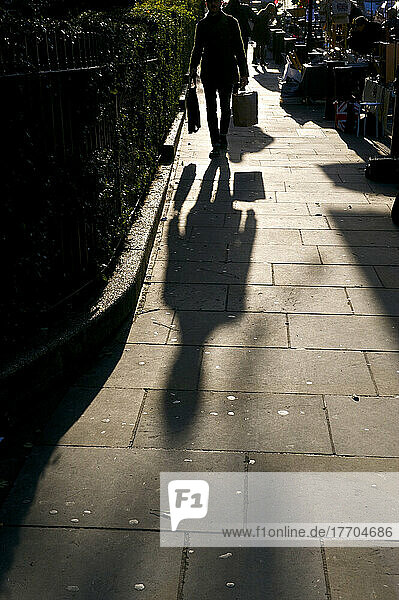 Geschäftsmann auf der Portobello Road bei Sonnenaufgang; London  England