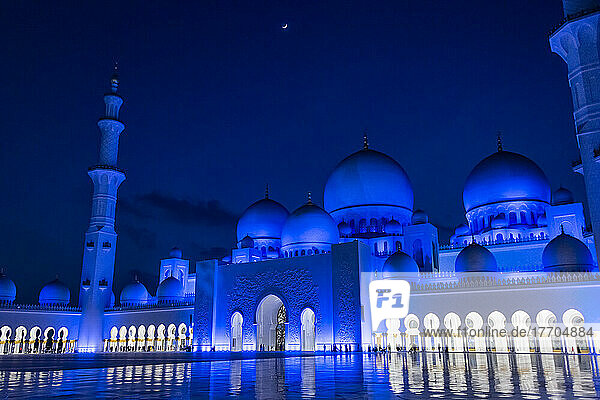 A view of the main entrance to the Grand Mosque in Abu Dhabi  UAE on a quarter moon lit night. The exterior lighting is designed to mimc the light cycles of the moon; Abu Dhabi  United Arab Emirates