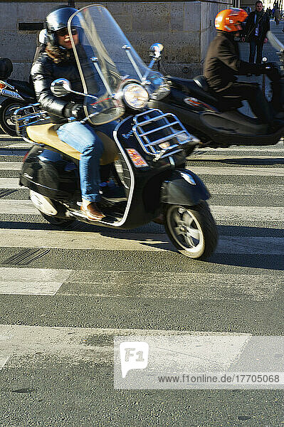 Ein Motorradfahrer auf einer Straße; Paris  Frankreich