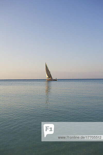 Ein Segelboot in der Ferne auf dem ruhigen Wasser des Indischen Ozeans; Vamizi Island  Mosambik