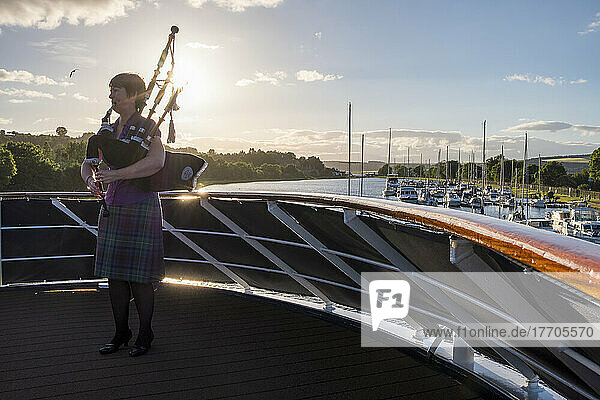 Ein Dudelsackspieler spielt am Bug eines Schiffes im Caledonian Canal in Inverness  Schottland; Inverness  Schottland