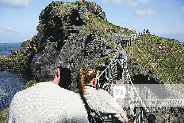 Überquerung der Carrick-A-Rede-Seilbrücke  einer Hängebrücke  die sich 20 Meter vom Festland zur winzigen Insel Carrick erstreckt; Grafschaft Antrim  Irland