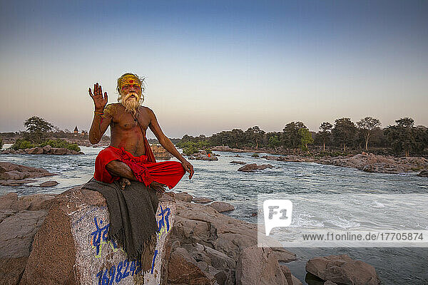 Sadhu  heiliger Mann  der auf einem Felsen am Betwa-Fluss sitzt; Orchha  Madhya Pradesh  Indien