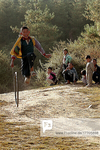 Einheimische Kinder aus Paro spielen mit Reifen am Stadtrand von Paro. Foto: Jill Mead Axiom Nov 2003