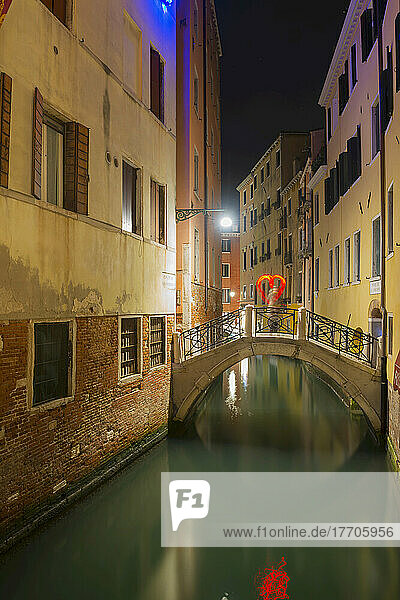 Ein ruhiger Kanal zwischen Gebäuden mit einer Herzform auf einer Fußgängerbrücke; Venedig  Venetien  Italien