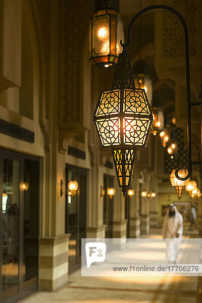 Mann in traditionellem arabischen Dishdasha-Outfit  der einen Korridor im Einkaufszentrum entlanggeht; Dubai  Vereinigte Arabische Emirate
