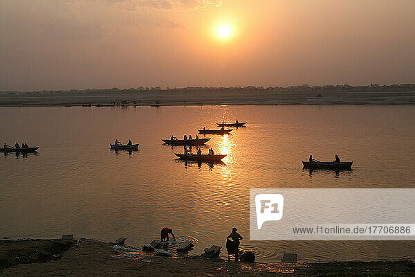 Boote auf dem Ganges und gewaschene Kleidung bei Sonnenaufgang. Die Kultur von Varanasi ist eng mit dem Ganges und der religiösen Bedeutung des Flusses verbunden: Sie ist die religiöse Hauptstadt Indiens und ein wichtiges Pilgerziel.