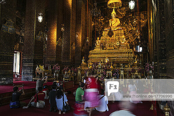 Touristen und Gläubige vor der Buddha-Statue im Wat Pho-Tempel in Bangkok.
