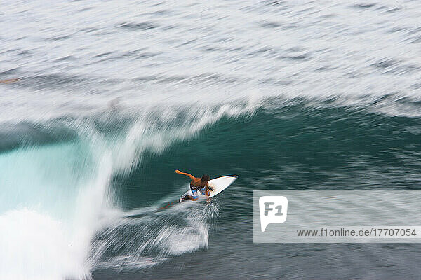 Ein Surfer bereitet sich darauf vor  über scharfe Korallen in Indonesien geschleudert zu werden.