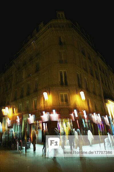Unschärfe der Lichter auf einem Gebäude in der Nacht und Fußgänger zu Fuß durch; Paris  Frankreich