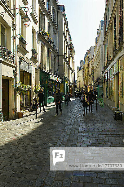 Fußgänger auf einem Gehweg zwischen Gebäuden im historischen Viertel Marais; Paris  Frankreich