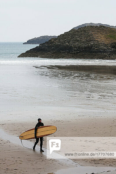 Surfer Coming Out Of The Chilly Winter Waters Heading To Car Park At Whitesands Beach On The Pembrokeshire Coast Path; Pembrokeshire  Wales