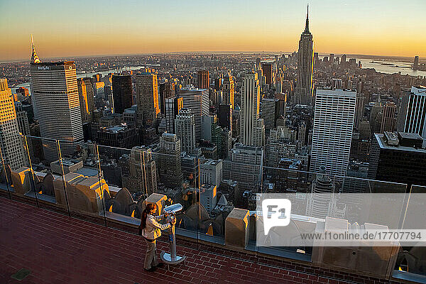 Tourist in der Dämmerung mit Blick auf New York City von einer Aussichtsplattform aus.