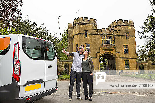 Ein Paar in einem Wohnmobil hält für ein Selfie vor dem Schloss Sudeley an; Winchcombe  England  UK