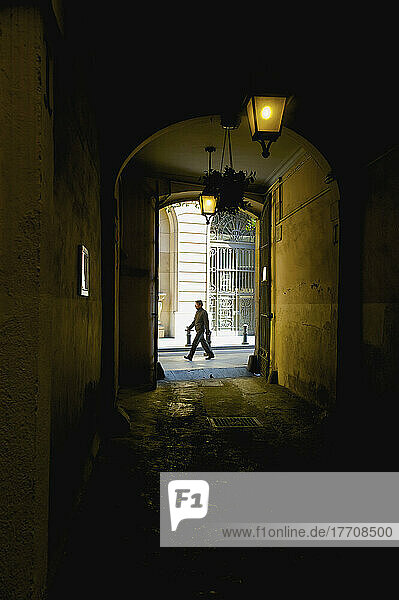 Blick durch einen dunklen Korridor auf einen Fußgänger  der auf der Straße vorbeigeht; Barcelona  Spanien