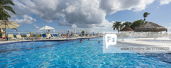 Tourists enjoy the resort swimming pool on a Caribbean island; Dominican Republic